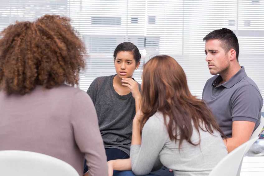 Four people sitting in a group session.