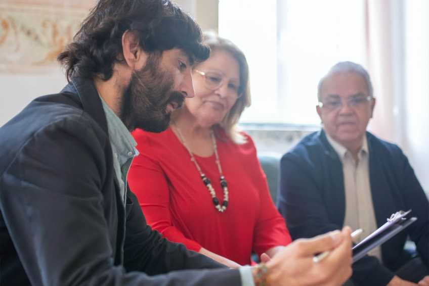 Young man coming to an agreement with older couple 