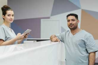 Two health care professionals talking over a counter